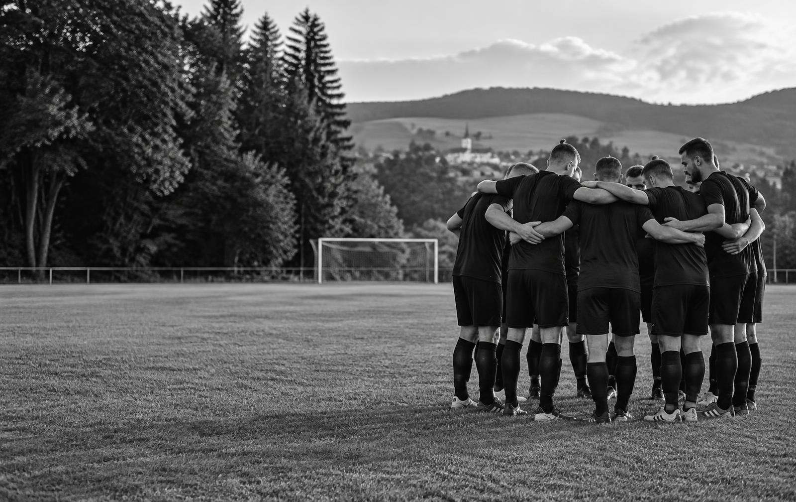 Symbolbild eines Fußballteams im gemeinsamen Mannschaftskreis